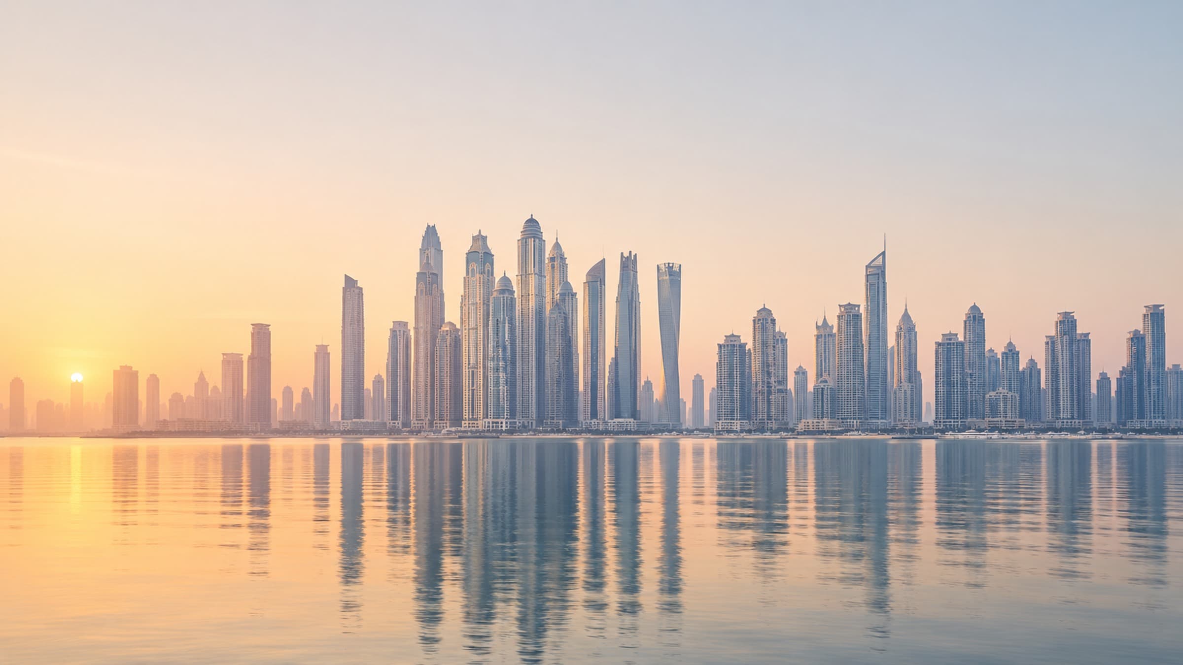 Dubai Marina and JLT skyline at dawn across still water